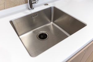 A close up look at a kitchen sink with a garbage disposal. RJ's Plumbing Service provides professional garbage disposal installation in Battle Ground WA.
