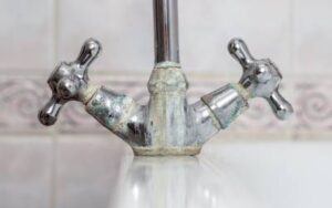 Faucet with limescale buildup on the base due to hard water